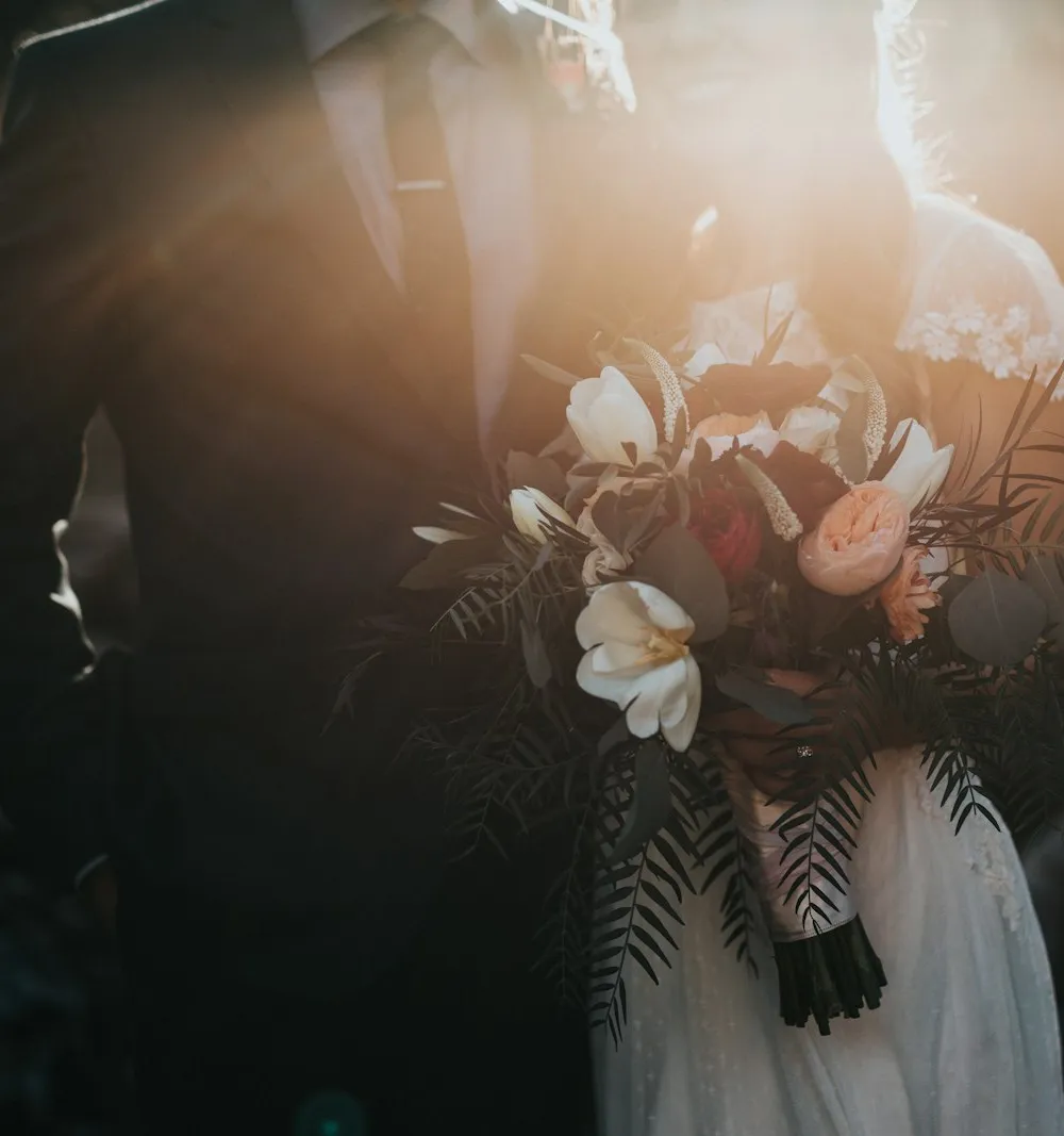 Couple walking hand in hand through a garden
