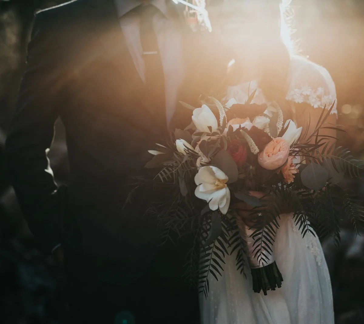 Couple walking hand in hand through a garden